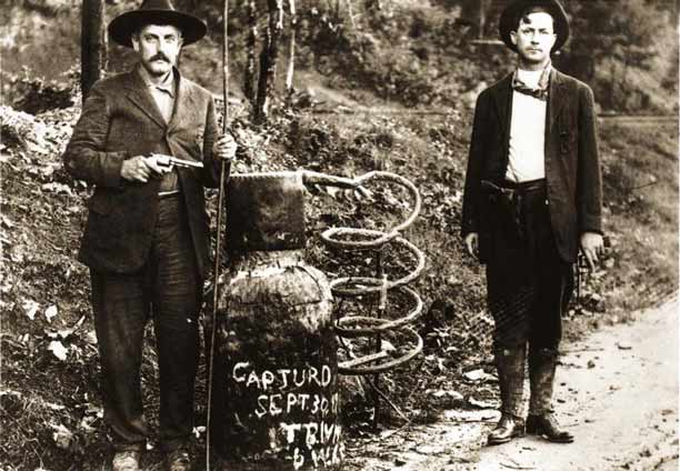 SM-captured-moonshine-still_NPSArchives_612x424 Law enforcement officers stand beside a captured moonshine still. Photo by NPS Archives
